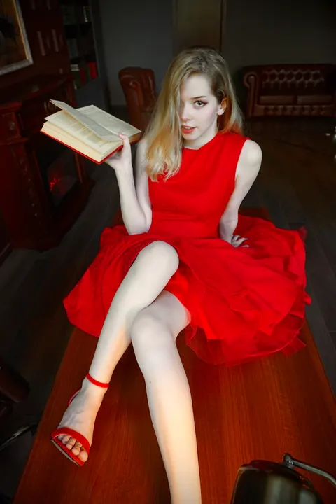 Red dress reading on a desk